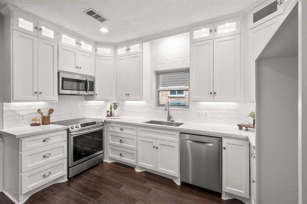Thoughtful features like large pot and pan drawers, a convenient Lazy Susan, a built-in garbage pull-out, and under-cabinet sliders make this kitchen as functional as it is beautiful.
