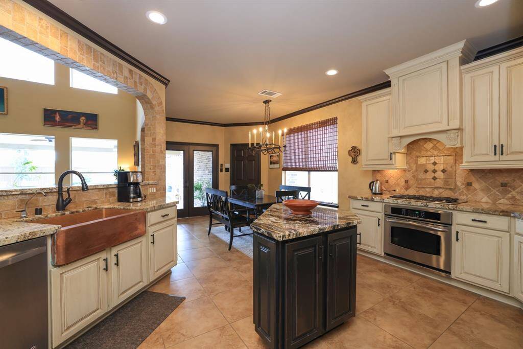 Double ovens and exhaust fan hidden behind custom arched cabinet. Custom painted island. Many of the lower cabinets have pull outs for ease in retreiving items.