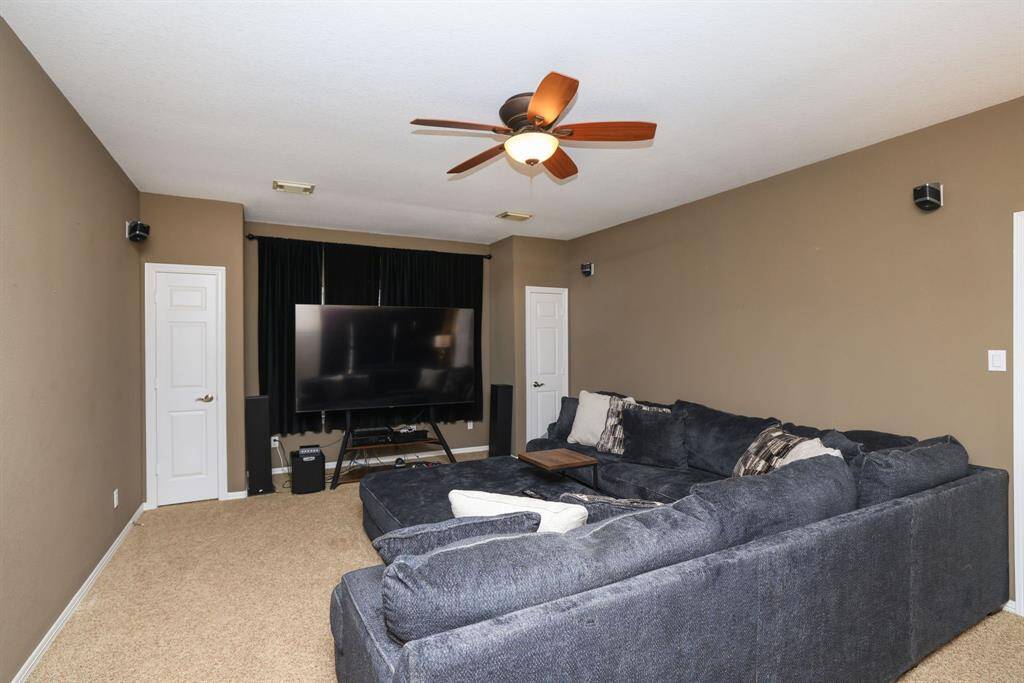 Media room with double storage closets. Windows behind the black out curtains. Speakers stay. This possible could be a sixth bedroom.