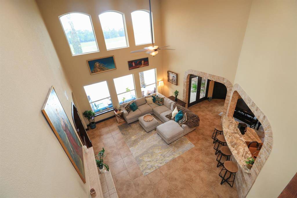 Standing on this catwalk area n the second floor, you can easily see through the stacked windows to the greenspace behind this property. Don't miss the stone surround and under the bartop seating area. Customized for that something extra!