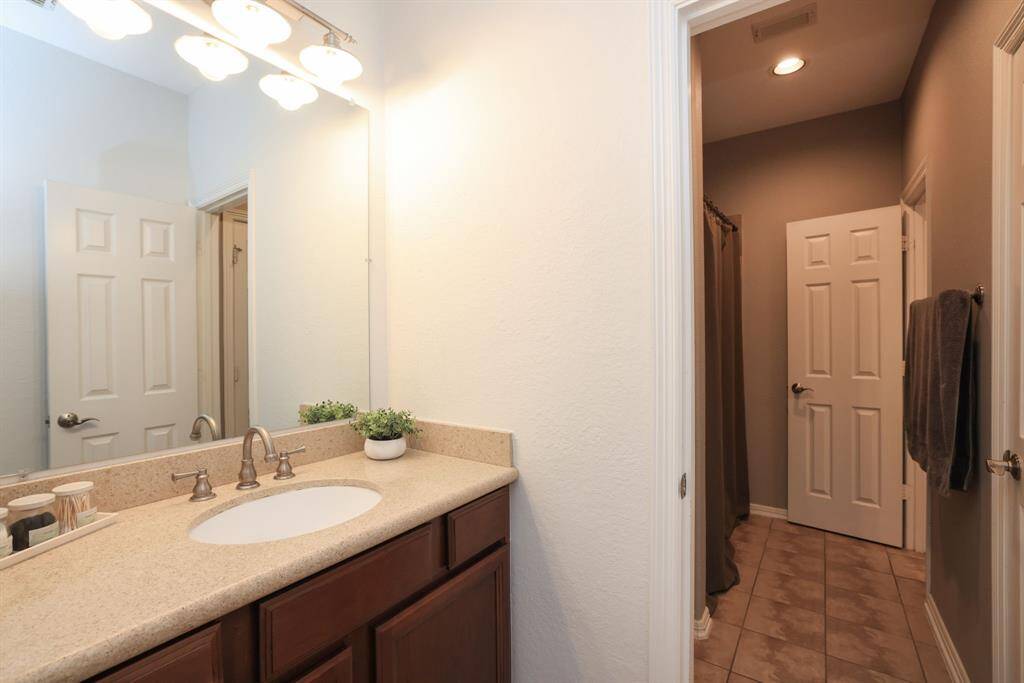 Vanity area of the Hollywood bath with door to bathing area and linen closet