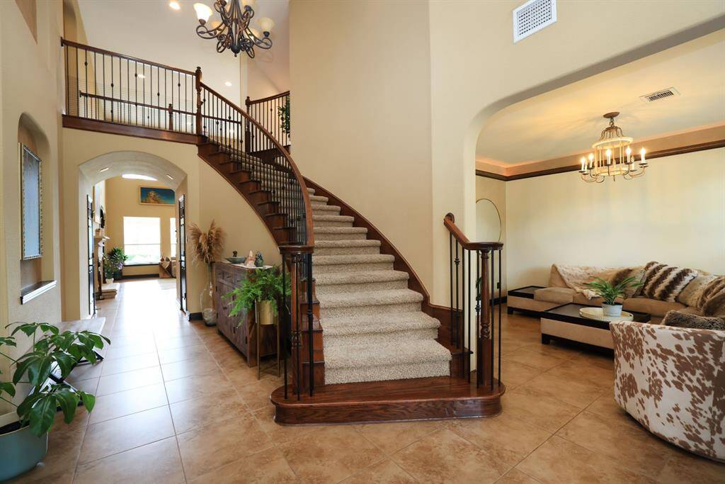 Two story entrance. Oversized tile for easy care. decorative chandelier