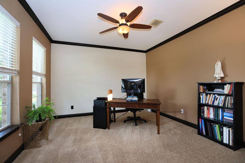 Welcoming study or living room with crown moding and double windows.