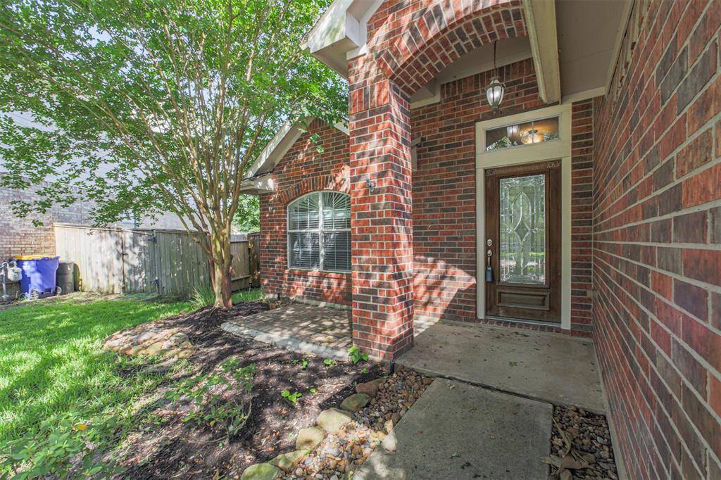 Welcoming covered porch with an elegant leaded glass door.