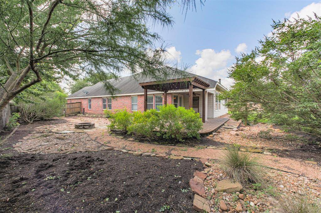 Large backyard with lush landscaping and firepit.