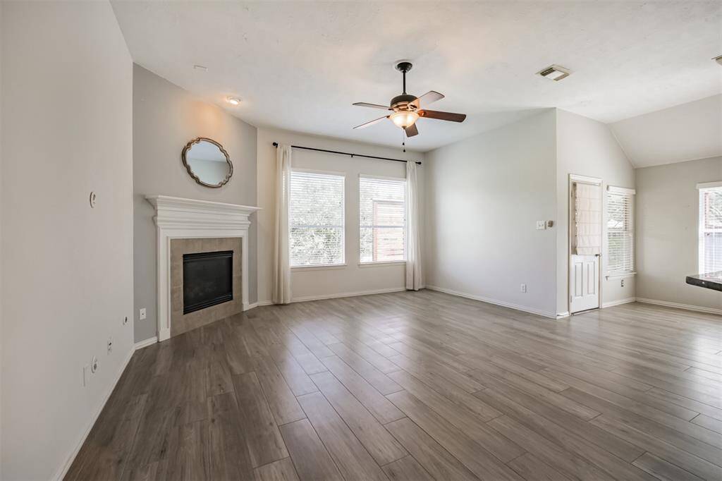 Spacious den featuring a cozy gas fireplace and ceiling fan for comfort.