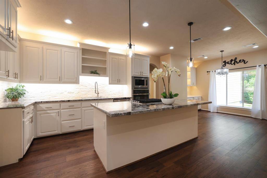 The heart of the home features a granite island kitchen with gas cooking, ideal for home chefs and everyday meals alike. Enjoy upper and lower cabinet lighting, stylish cabinet hardware, and stainless steel appliances, including a convection wall oven, all combining function and elegance in this well-appointed space.