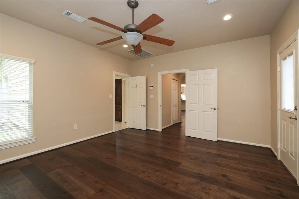 The primary bedroom is a peaceful retreat featuring direct access to the backyard and outdoor living area, perfect for enjoying a quiet morning coffee or winding down under the stars. A seamless blend of comfort and convenience.