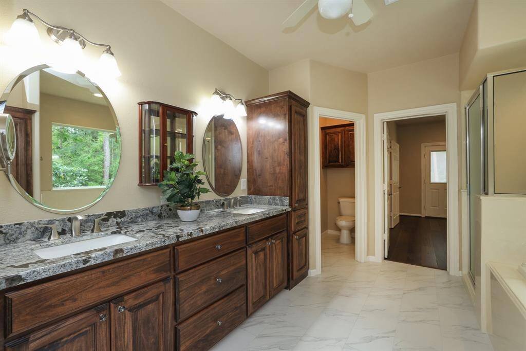 The primary retreat offers easy-care tile flooring and a spacious walk-in shower, combining style and practicality.