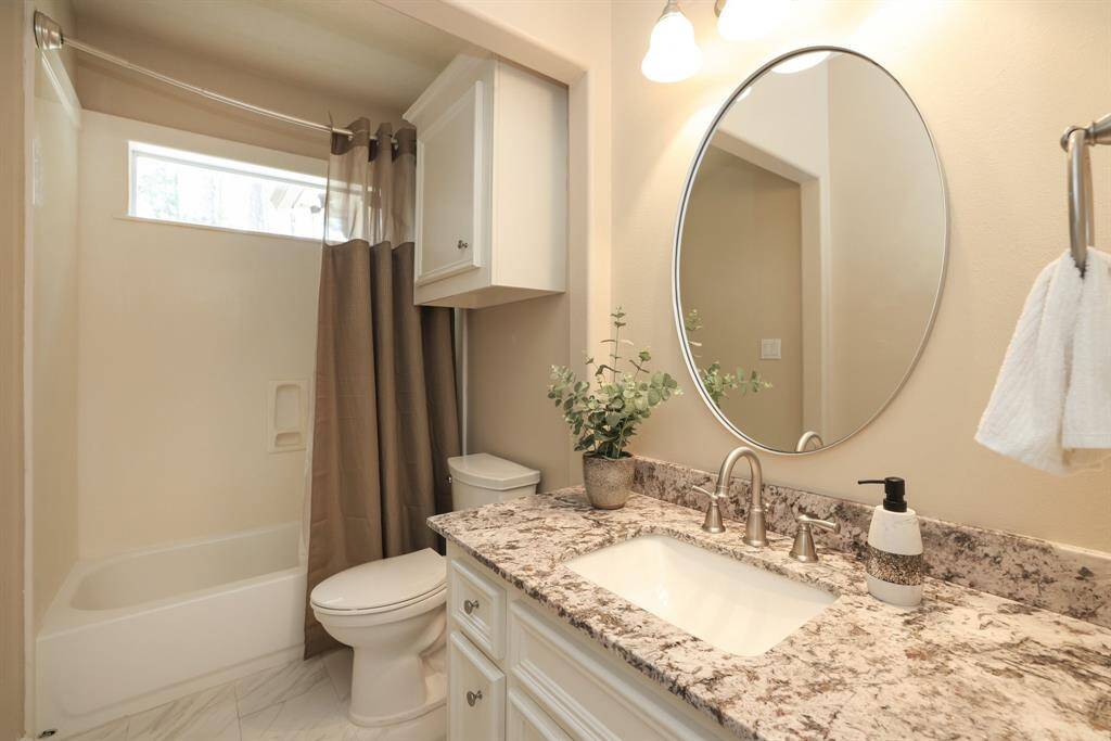 The full bathroom serving the secondary bedrooms is beautifully updated and thoughtfully designed. Enjoy plenty of natural light, stylish finishes, and a functional layout—making it a welcoming space for family or guests.