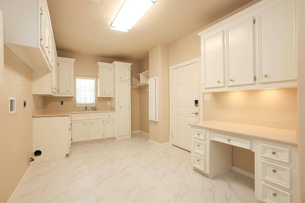 WOW! You’ll love this versatile mud/utility/study area, a true multi-functional space with storage galore. Features include a built-in ironing board, broom closet, hanging rod, and plenty of cabinetry. Whether you're managing laundry, organizing household items, or tackling daily tasks, this space has it all. Plus, enjoy direct access to your oversized attached garage for added convenience.