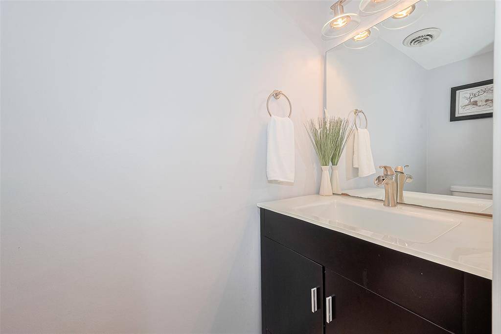 This stylish half bath is conveniently located just off the hallway, offering easy access for guests without compromising privacy. A perfect blend of accessibility and design for everyday living and entertaining.