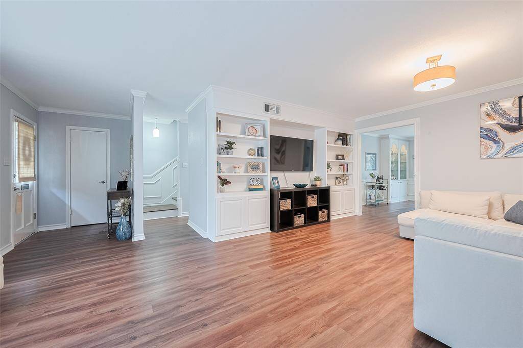 Spacious open living room with built in shelving and storage cabinets.