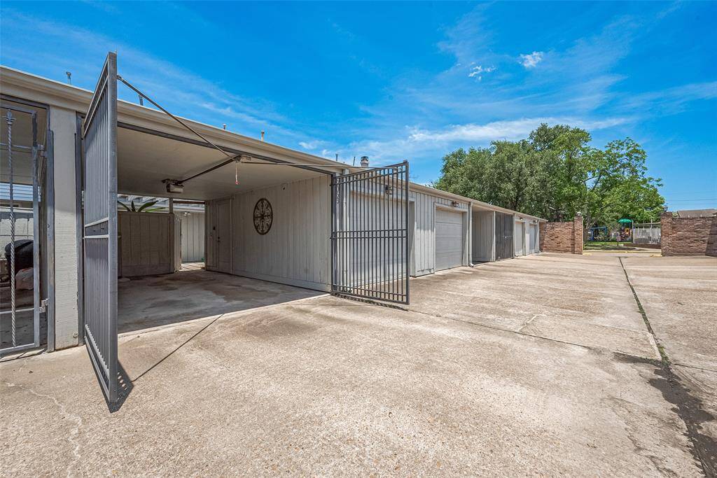 Auto gated carport with a second storage garage next door.