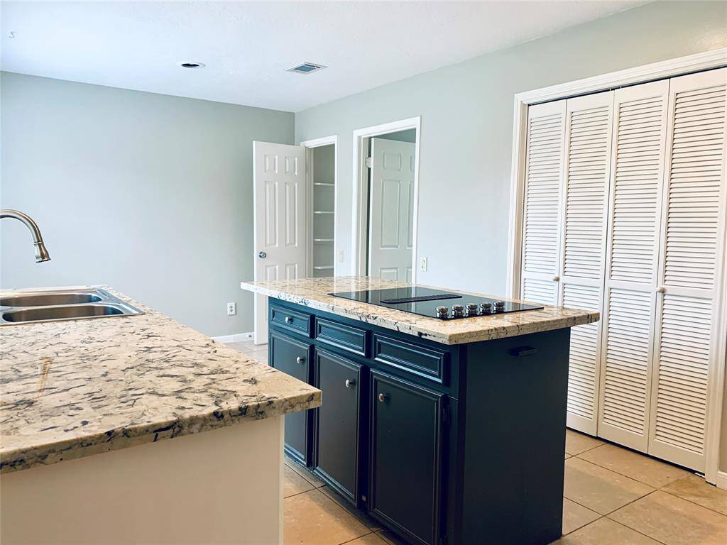 Island kitchen with electric cooktop! Accordion doors with pantry storage.