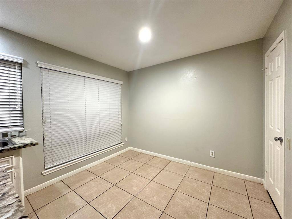 The breakfast room is just off the kitchen with a large window view of the front.