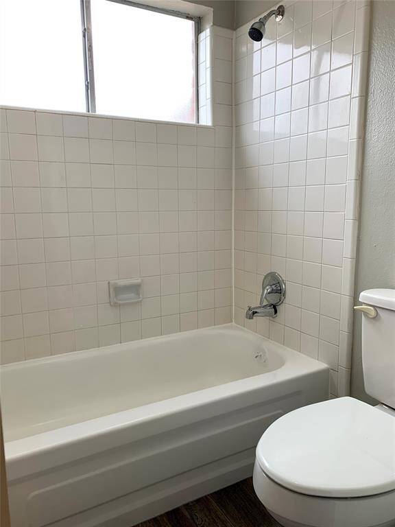 The wood laminate flooring continues into this hall bath with tub/shower combo.
