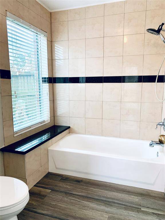 Primary bathroom features the new wood laminate flooring and window with ledge!