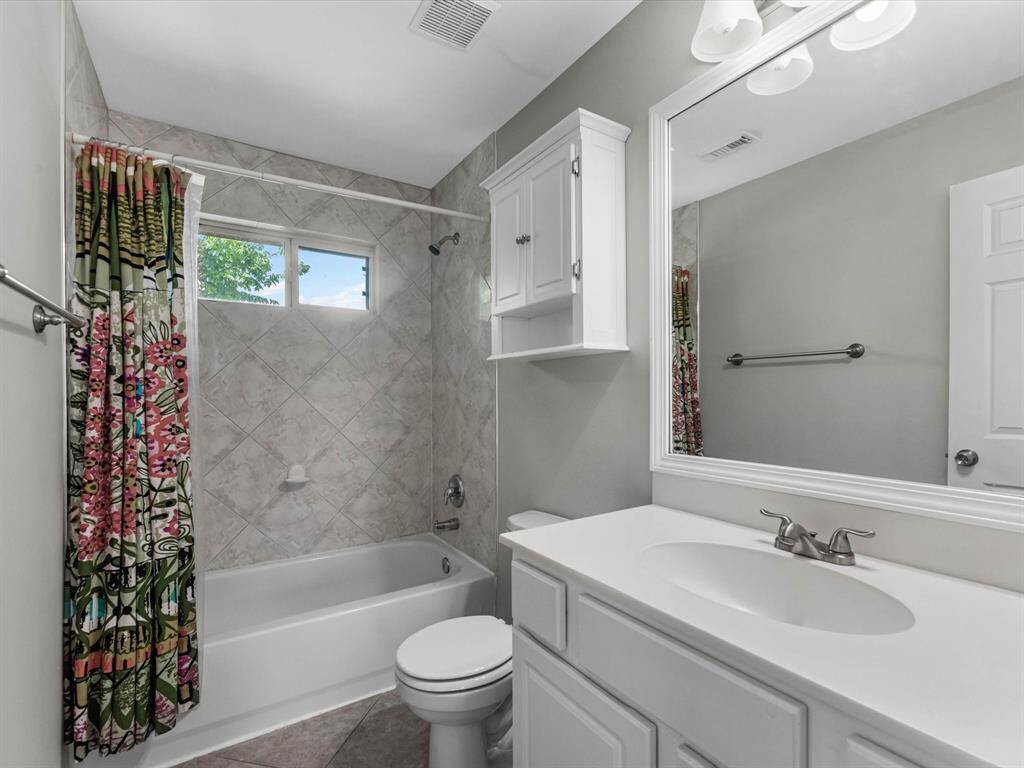 Adjacent to the secondary bedroom is the secondary bathroom, featuring a shower/tub combo.
