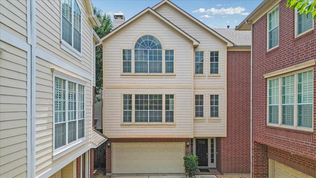 A welcoming facade featuring a timeless combination of brick and siding, expansive windows, and a private two-car garage—all with no shared walls for added privacy and peace.