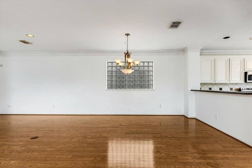 Spacious dining area framed by elegant crown molding and a glass block feature wall—ideal for entertaining or intimate dinners.