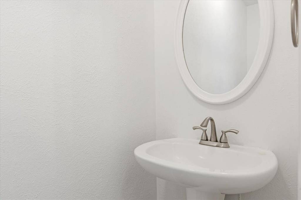 Convenient powder room tucked away on the second floor with pedestal sink and oval mirror—perfect for guests.Convenient powder room tucked away on the second floor with pedestal sink and oval mirror—perfect for guests.