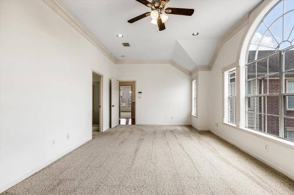 Another angle of the primary suite shows the entrance to the luxurious en-suite bath and a glimpse of the adjacent sitting area or hallway.