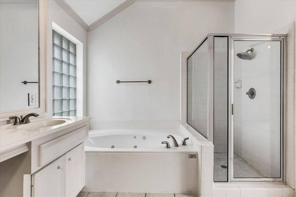 Separate glass-enclosed shower and jetted soaking tub offer the perfect combination of function and luxury.