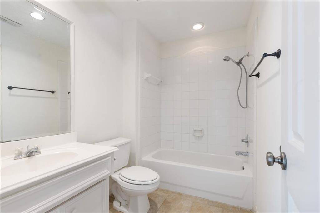 Private full bath connected to the downstairs bedroom, featuring a soaking tub with shower, neutral tile flooring, and a classic vanity—perfect for guests or long-term stays.Private full bath connected to the downstairs bedroom, featuring a soaking tub with shower, neutral tile flooring, and a classic vanity—perfect for guests or long-term stays.