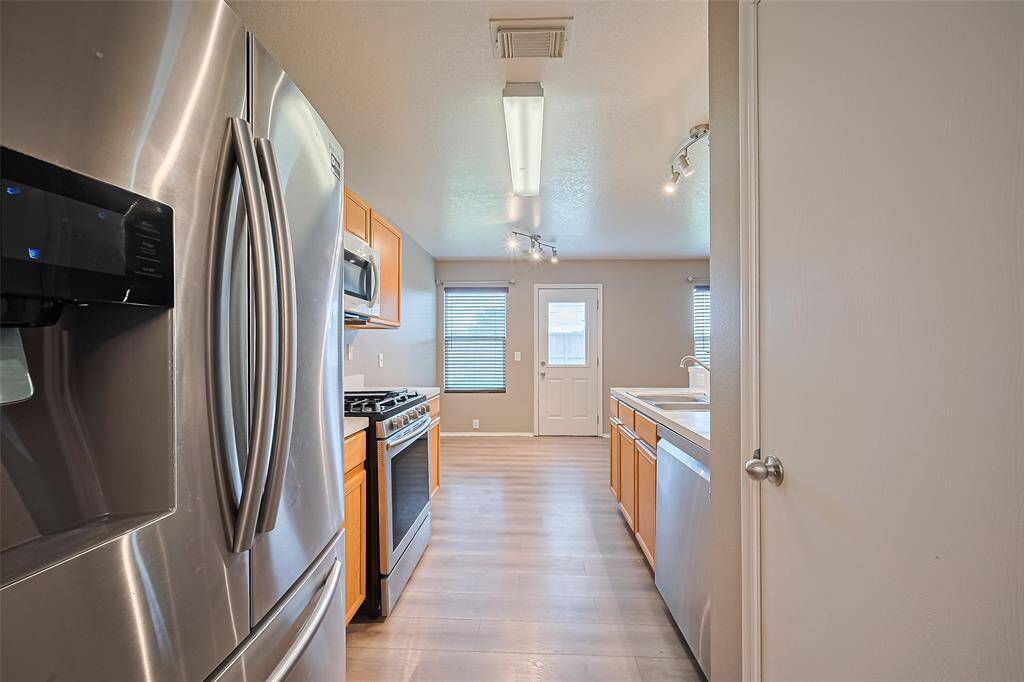 Stainless steel appliances with a walk in pantry.