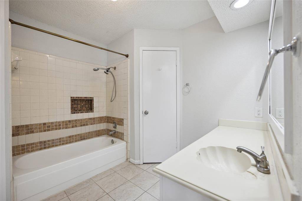 Elegant master bathroom featuring a stylish shower backsplash and a spacious vanity area.