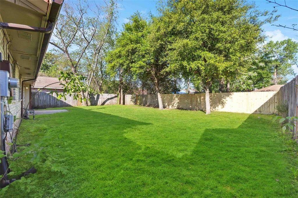 Enjoy the serene ambiance of a spacious backyard featuring a majestic tree, perfect for shade and relaxation.