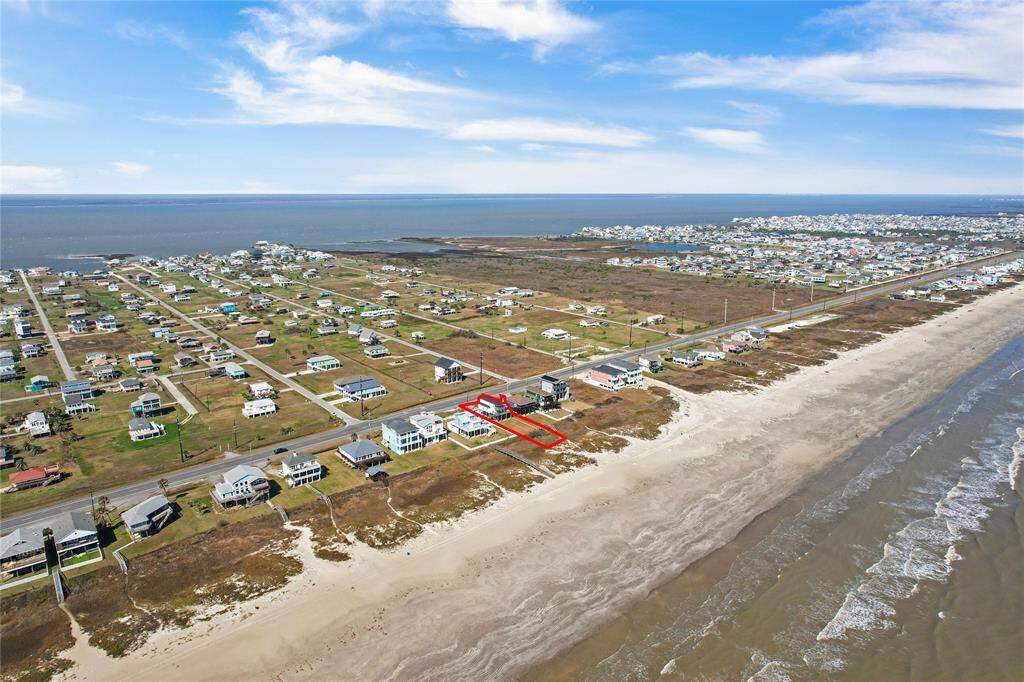 This aerial photo showcases a beachfront property with direct access to the ocean, highlighted by a red outline. The area is a mix of residential homes, offering a serene coastal community vibe, ideal for those seeking a seaside lifestyle.
