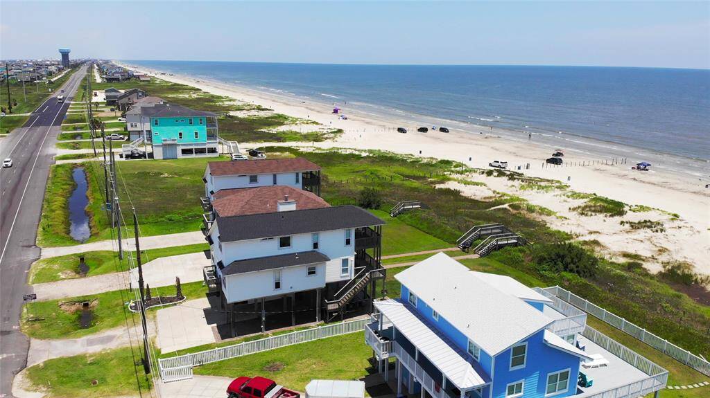 This photo showcases beachfront properties with a stunning view of the ocean. The homes are set back from a wide, sandy beach, perfect for relaxation and recreation. The area appears peaceful and well-maintained, ideal for those seeking a coastal lifestyle.