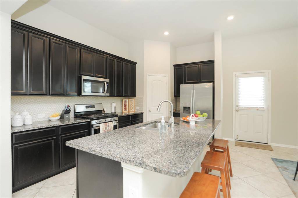 Beautiful countertops enhance the island kitchen with large sink and designer plumbing features.