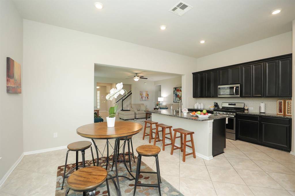 . The open layout flows seamlessly into the living area, perfect for entertaining. A cozy dining  nook with a round table completes the space.