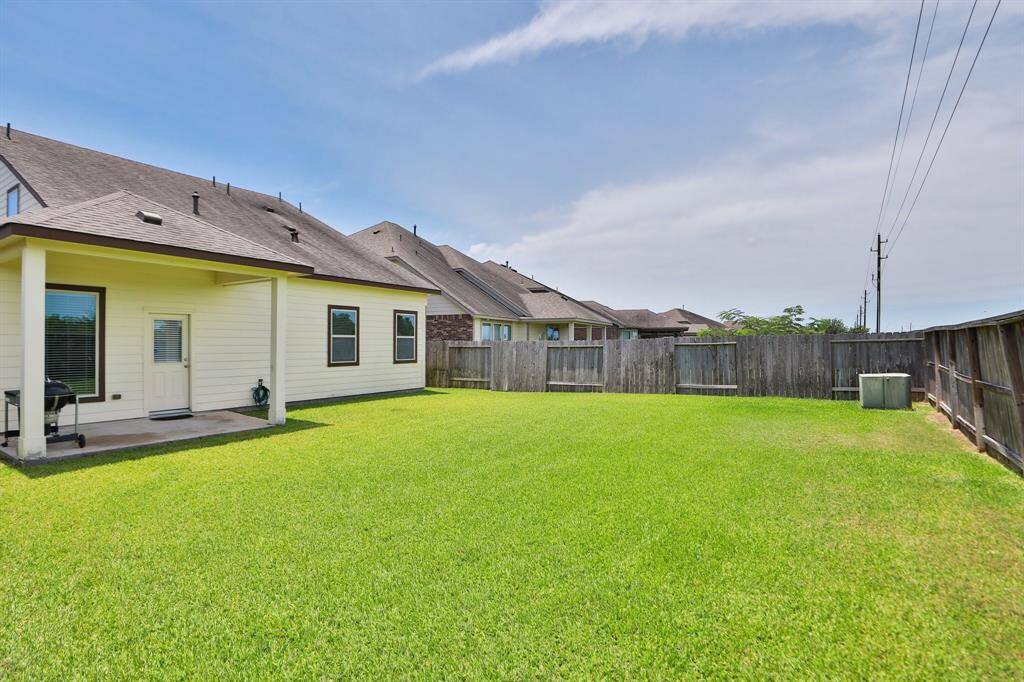 This photo shows a spacious backyard with a well-maintained lawn, enclosed by wooden  and is ideal for outdoor activities.