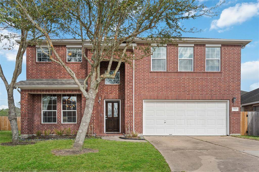 This is a two-story brick home featuring a double garage, a neatly landscaped front yard, and large windows that offer ample natural light. Ideal for those seeking a spacious and inviting property.