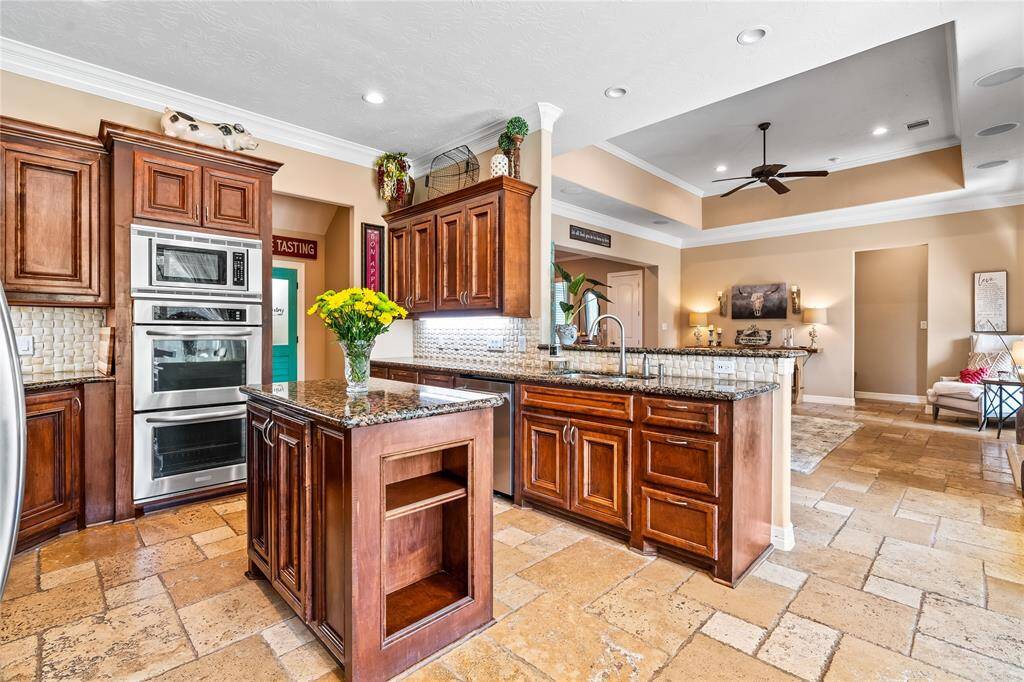TASTEFULLY DESIGNED WITH TONS OF CABINETS, GORGEOUS GRANITE COUNTERS, AND A CUSTOM TILE BACKSPLASH.