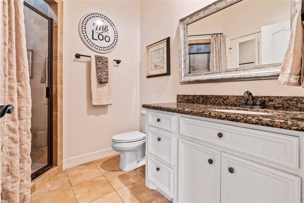 SECONDARY BATHROOM INCLUDES A GRANITE VANITY AND GLASS-ENCLOSED WALK-IN SHOWER.
