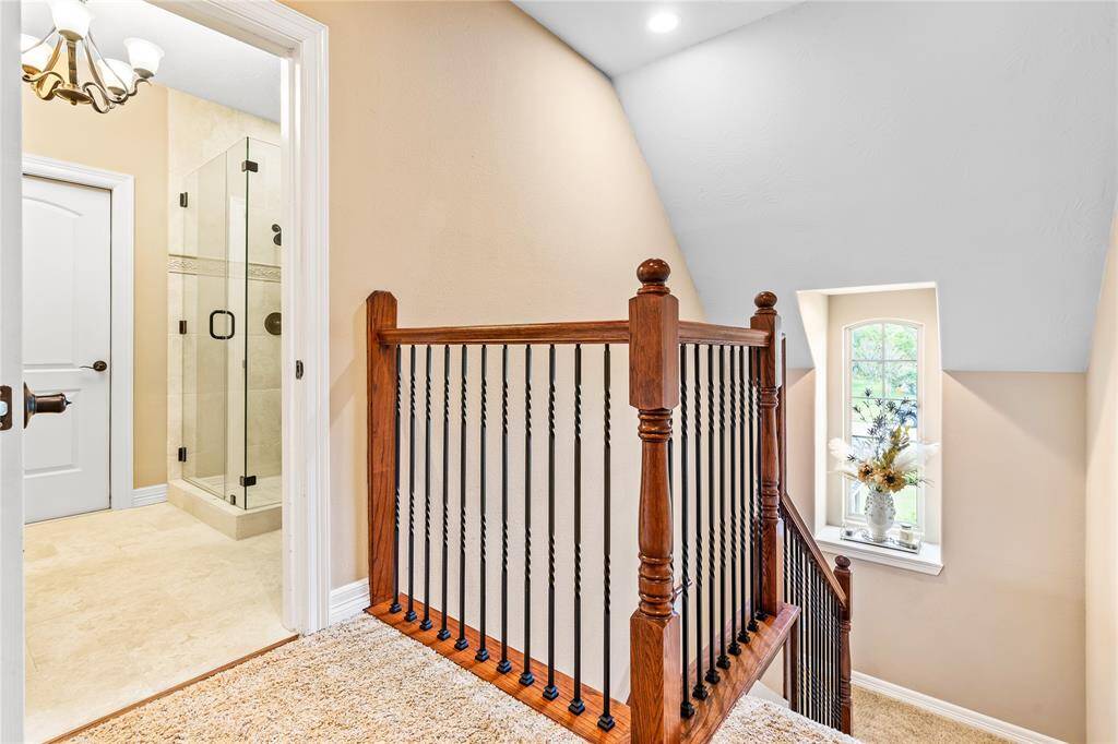 UPSTAIRS LANDING WITH WROUGHT IRON BALUSTERS AND A DECORATIVE WINDOW NICHE.