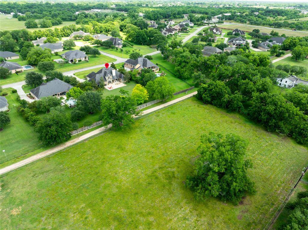 AERIAL VIEW WITH PIN DROP SHOWING THE HOME’S PRIME LOCATION ON A MASSIVE LOT WITH NO BACK NEIGHBORS.