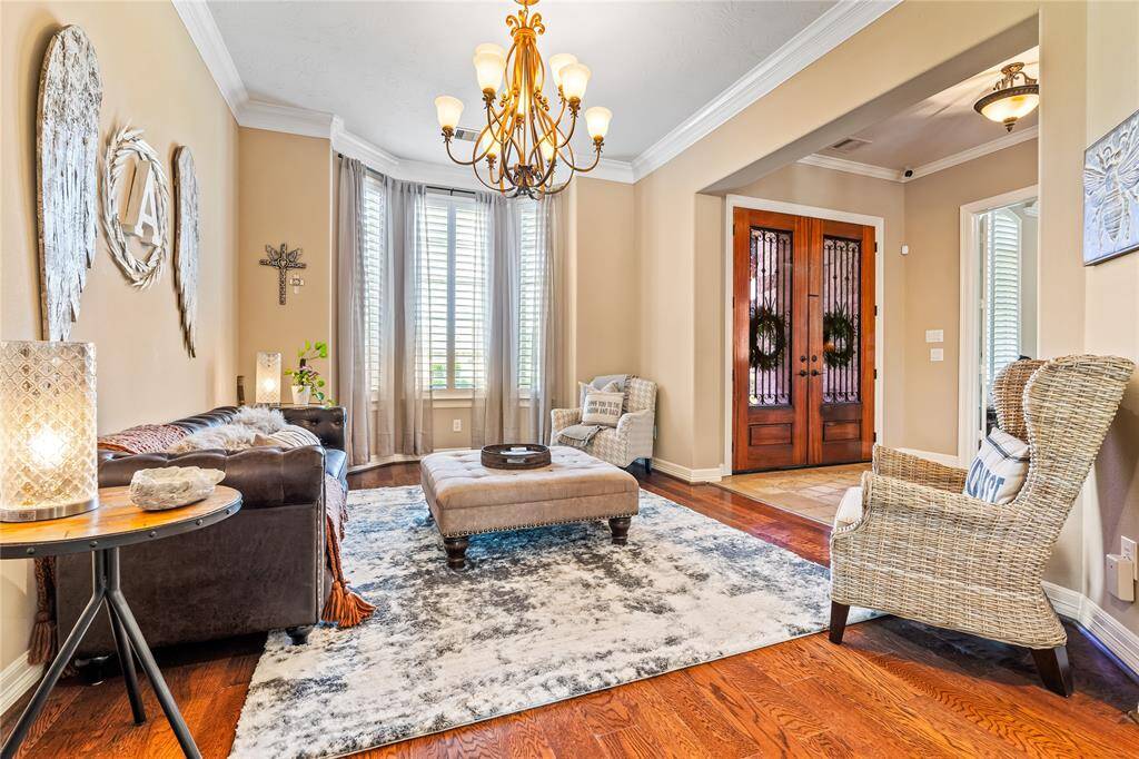 BRIGHT LIVING AREA FEATURING HUGE WINDOWS, CLASSIC CHANDELIER, AND TONS OF NATURAL LIGHT.