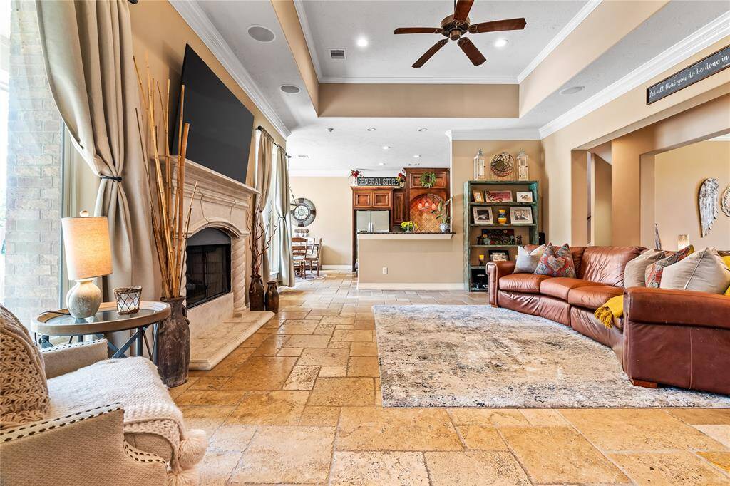 COZY FAMILY ROOM WITH A STATELY FIREPLACE, OPEN TO THE KITCHEN AND BREAKFAST AREA FOR EASY GATHERINGS.
