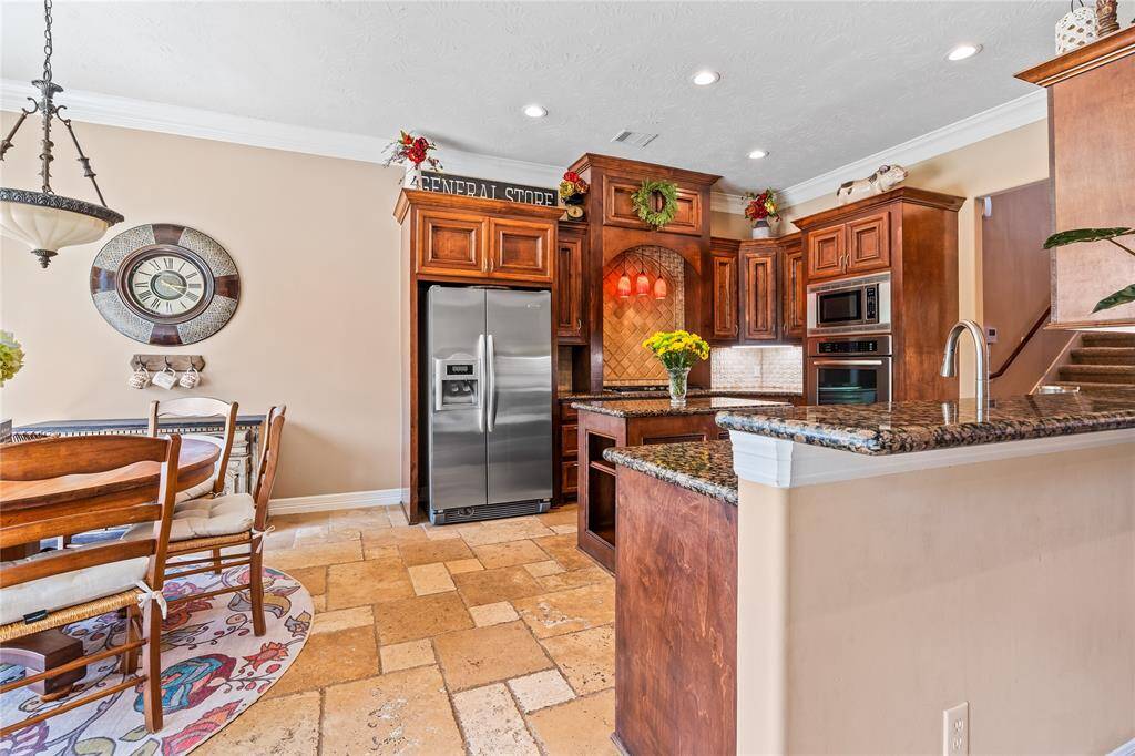 BEAUTIFUL KITCHEN WITH BREAKFAST BAR, BREAKFAST AREA, AND GRANITE COUNTERTOPS FOR EVERYDAY COMFORT.