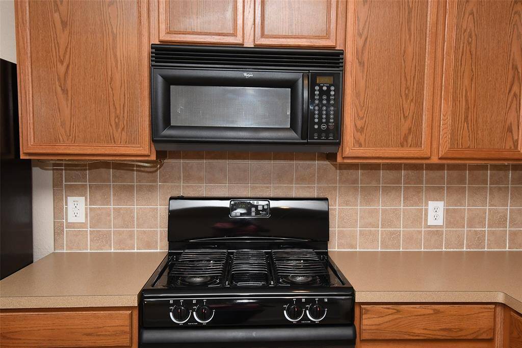 5 burner gas range with vent and microwave above.