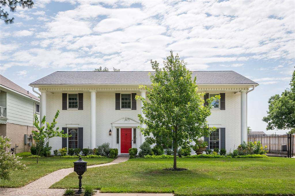 Discover your dream home at 2802 Bernadette Ln. This elegant residence boasts classic architecture, a striking red door, and lush landscaping, offering curb appeal and comfort in Spring Shadows.