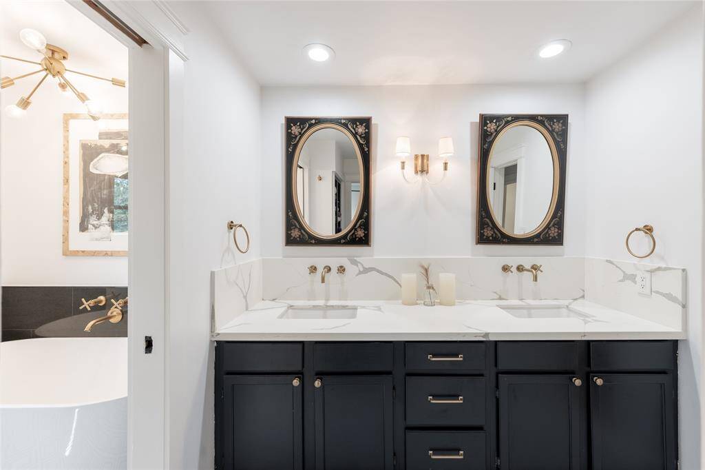 This stylish secondary bathroom has dual sinks with a standalone soaking tub and shower.