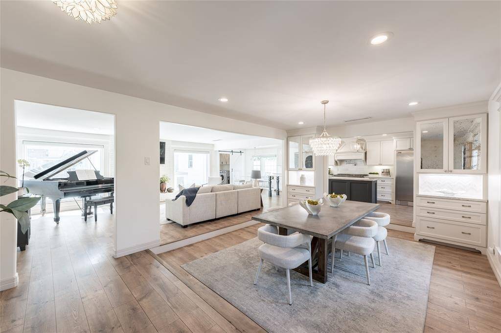 This large and bright, open-concept home features a modern kitchen with sleek cabinetry, a cozy living area, a spacious dining area that is perfect for entertaining and family living.