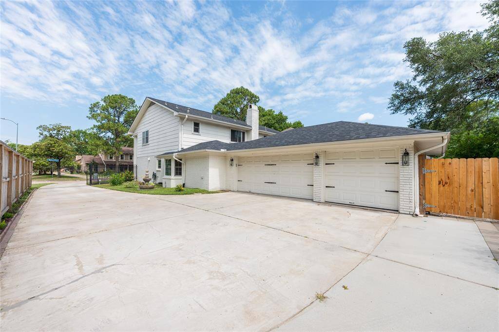 This home features a large driveway, a three-car garage, and an automatic gate.